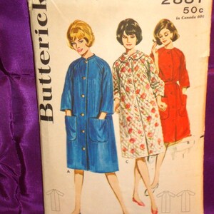 May include: A vintage Butterick sewing pattern envelope, number 2887, size 14, bust 34. The illustration displays three coat variations: a solid blue coat, a white coat with a red floral pattern, and a solid red coat, all featuring front buttons.