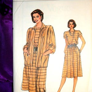 May include: Vintage Very Easy Vogue sewing pattern featuring a woman in a tan plaid suit and dress. The pattern includes a jacket, skirt, and dress. The size is 14-16-18.
