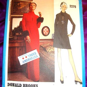 May include: A Vogue Americana sewing pattern envelope, number 2276 by Donald Brooks. The cover features a photograph of a person in a long red dress with dark fur cuffs and a sketch of a short dark dress with a high neckline and a keyhole cutout.