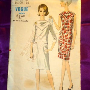 May include: A vintage Vogue sewing pattern envelope numbered 6693, size 14, featuring illustrations of two dresses. One is a solid light-colored dress with a cowl neckline and three-quarter sleeves, the other a sleeveless dress with a red and black grid pattern.