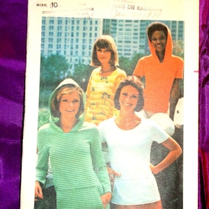 May include: Vintage Butterick sewing pattern 4668 featuring four models wearing hooded tops and a skirt. The pattern includes a green striped hooded top, an orange hooded top, a yellow top, and a white top with a skirt. The pattern is sized for moderate stretch knits.