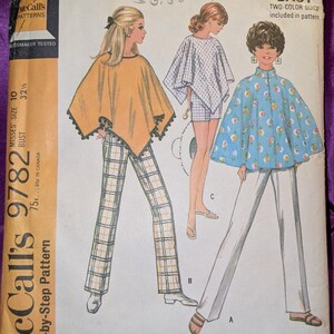 May include: A vintage McCall's 9782 sewing pattern envelope for a set of ponchos, pants, and shorts. The cover features illustrations of three outfits: a yellow poncho with plaid pants, a white checkered poncho with shorts, and a blue floral poncho with white pants.