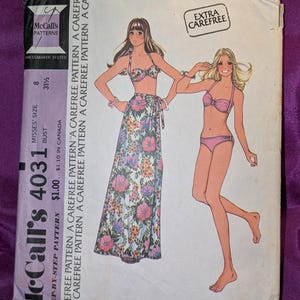 May include: Vintage McCall's 4031 sewing pattern for a Misses' bikini swimsuit and skirt. The pattern features illustrations of the designs, with a floral print skirt and bikini top. The package includes the text "Extra Carefree".