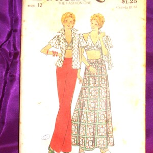 May include: A Butterick 3706 sewing pattern envelope for size 12. The illustration shows two outfits: one with red trousers and a floral print shirt, and another with a matching floral print crop top and long skirt. The text includes Butterick 3706.