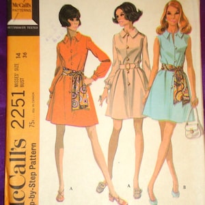 May include: Vintage McCall's 2251 sewing pattern featuring three dress designs. The dresses are shown in orange, beige, and light blue, each with a matching scarf. The pattern includes sizes for a 36-inch bust and is step-by-step.
