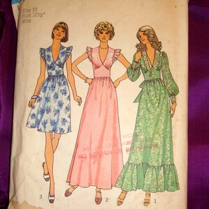 May include: Vintage Simplicity sewing pattern 6899 featuring three dress designs. The pattern includes a size 10 with a bust of 32 1/2 inches. The illustrations depict dresses in blue floral, pink, and green floral patterns. The pattern's brand name is Simplicity.