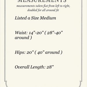 May include: Cream-colored card with black text detailing garment measurements. The text includes "MEASUREMENTS," "Listed a Size Medium," waist measurements of 14"-20" (28"-40" around), hip measurements of 20" (40" around), and an overall length of 28 inches.