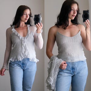 Puede incluir: Una blusa gris claro transparente de manga larga con ribete de volantes y un camisole a juego. El camisole tiene tirantes finos. Ambas blusas se combinan con vaqueros azul claro. El atuendo es adecuado para superponer.
