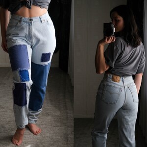 May include: Two women wearing light blue denim jeans. The jeans on the left have patchwork details in blue and navy. The jeans on the right are a solid light blue.