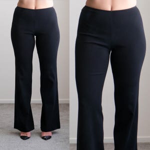 May include: Black, flared-leg pants. The pants have a high waist and a smooth, solid texture. The legs of the pants flare out from the knee down. The pants are made of a stretchy material.