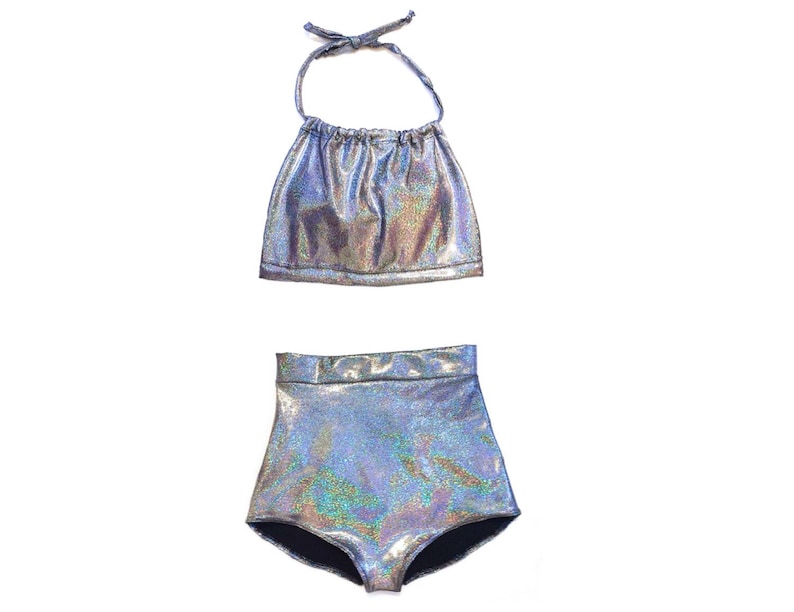 May include: A silver iridescent halter top and high-waisted bikini bottoms. The fabric has a shimmery, holographic finish.
