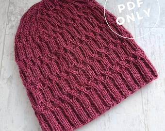 May include: A burgundy knitted hat with a textured stitch pattern. The hat is made with a soft yarn and has a comfortable fit. The image includes the text "PDF ONLY" and "KNITTING PATTERN".
