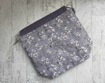 Medium project bag for knitting, crochet, needlework; white and black flowers on a gray background drawstring pouch with pockets
