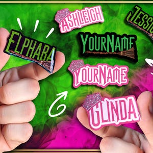May include: A selection of name badges with a witchy theme. The badges display names such as "Elphaba," "Ashleigh," "Jessica," and "Linda" in different fonts and colours, with a broom graphic. The background is green and pink.