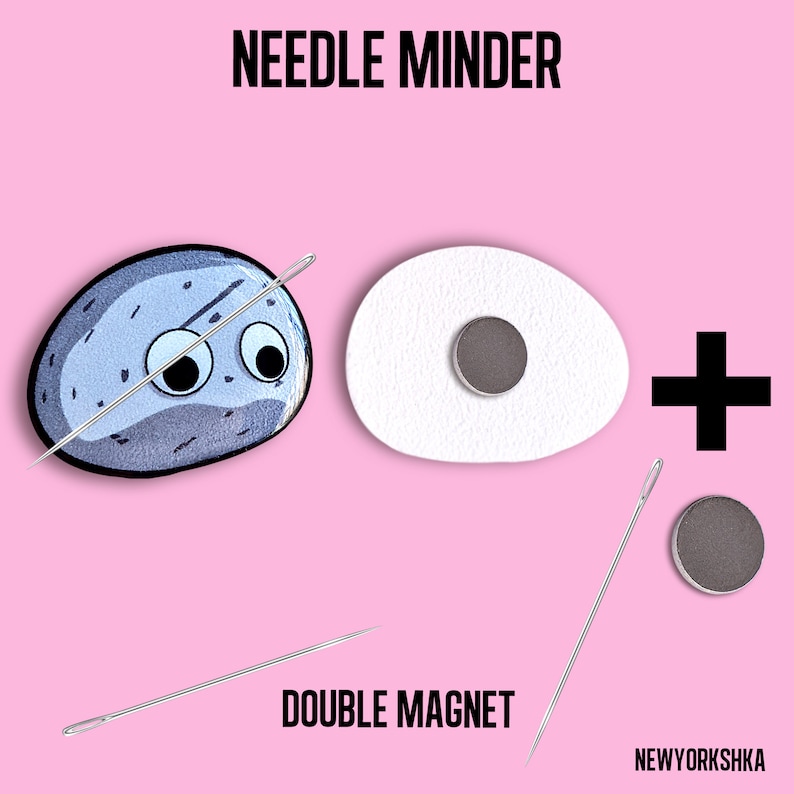 May include: A needle minder set with a cartoon rock design, a white egg-shaped piece, and a double magnet. The text "NEEDLE MINDER" and "DOUBLE MAGNET" are displayed on a pink background.
