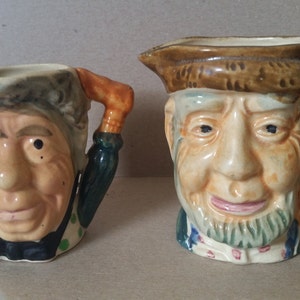 A Pair of Character Toby Mugs, the umbrella couple, old man old lady