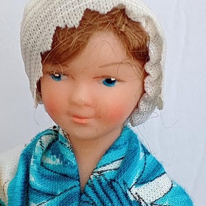 Doll,  miniature charters plastic doll with a blue and white dress.