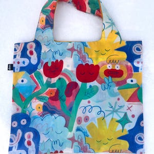 May include: A colorful reusable shopping tote bag with a whimsical design featuring cartoon faces, flowers, and abstract shapes. The bag is made of a lightweight, water-resistant material and folds up for easy storage.