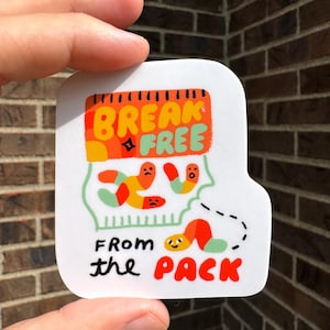 May include: White sticker with the words "BREAK FREE" in orange and green, and "FROM the PACK" in black and red. The sticker features cartoon worms and a dotted line.