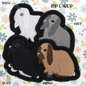 May include: Four embroidered patches of lop-eared rabbits in black, white, brown, and grey. The patches are labeled "Black", "White", "Brown", and "Grey". The text "Lop Eared" is at the top of the image.