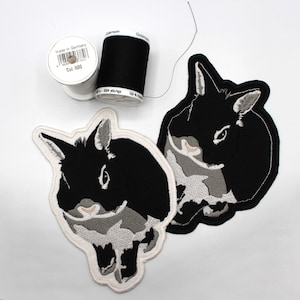 May include: Two black and white embroidered iron-on patches of a rabbit. The rabbit is facing the left side of the image. The patches are on a white background.