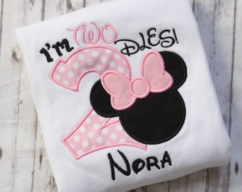 May include: White t-shirt with pink and white polka dot number two, a pink bow, and black Mickey Mouse ears. The text "I'm Two Dles!" and "Nora" are embroidered on the shirt.