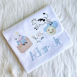 Puede incluir: Un body blanco para beb&eacute; con personajes bordados del libro infantil "La Oruga Muy Hambrienta" y el nombre "Adam Jr."