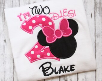 May include: White t-shirt with pink and white polka dot number two, a pink bow, and black Mickey Mouse ears. The text "I'm Two D's!" is above the number and the name "Blake" is below the number.