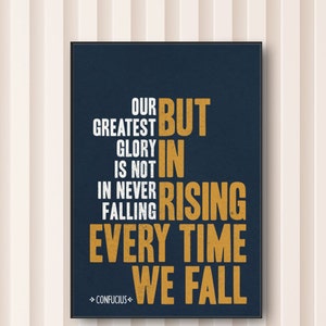 May include: A navy blue canvas print with a motivational quote in gold lettering. The quote reads "Our greatest glory is not in never falling, but in rising every time we fall." The quote is attributed to Confucius.