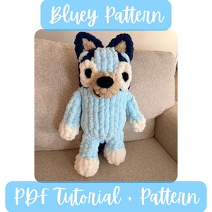 May include: A light blue crochet plush toy in the shape of a cartoon dog, with dark blue ears and accents, and a tan snout. The text "Bluey Pattern" and "PDF Tutorial + Pattern" are in light blue boxes.