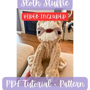 May include: A handmade, tan-colored sloth stuffie with a cream-colored face and brown accents. The sloth is sitting on a beige surface. Text on the image reads "Sloth Stuffie", "Video Included", and "PDF Tutorial + Pattern".