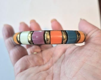 May include: A colorful bangle bracelet with segments of orange, teal, purple, and cream. The segments are separated by gold-colored metal. This bracelet is a vibrant accessory.