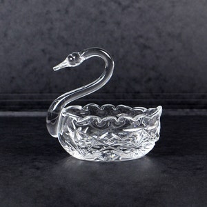 以下が含まれることがあります： カットガラスのデザインが施された、透明なガラス製の白鳥の形をした皿。ジュエリーや小物などの小さなものを収納するのに最適です。