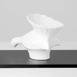 Könnte beinhalten: Weiße Keramikvase mit abstrakter, organischer Form. Die Vase hat eine breite Öffnung und einen schmalen Boden.