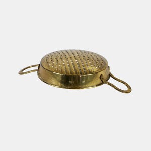 Könnte beinhalten: Ein Vintage-Messing-Sieb mit perforierter Schüssel und zwei gebogenen Griffen. Das Sieb hat einen goldenen Farbton und dient zum Ablassen von Flüssigkeiten aus Lebensmitteln. Die Schüssel hat einen Durchmesser von etwa 23 cm.
