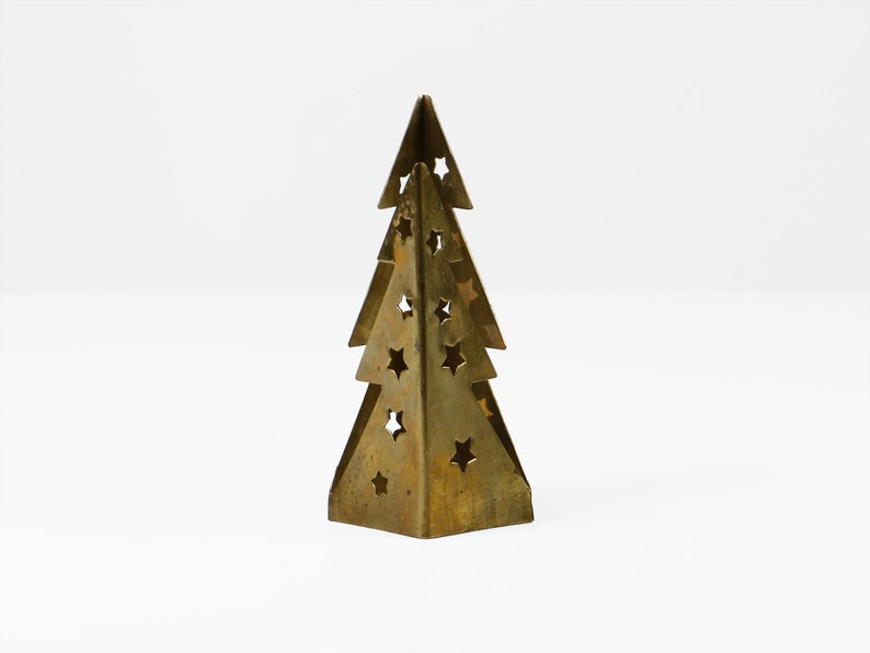 May include: A gold metal Christmas tree ornament with a cut-out star design.
