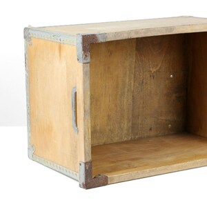 May include: A wooden box with metal trim and a handle. The box is empty and has a light brown color.