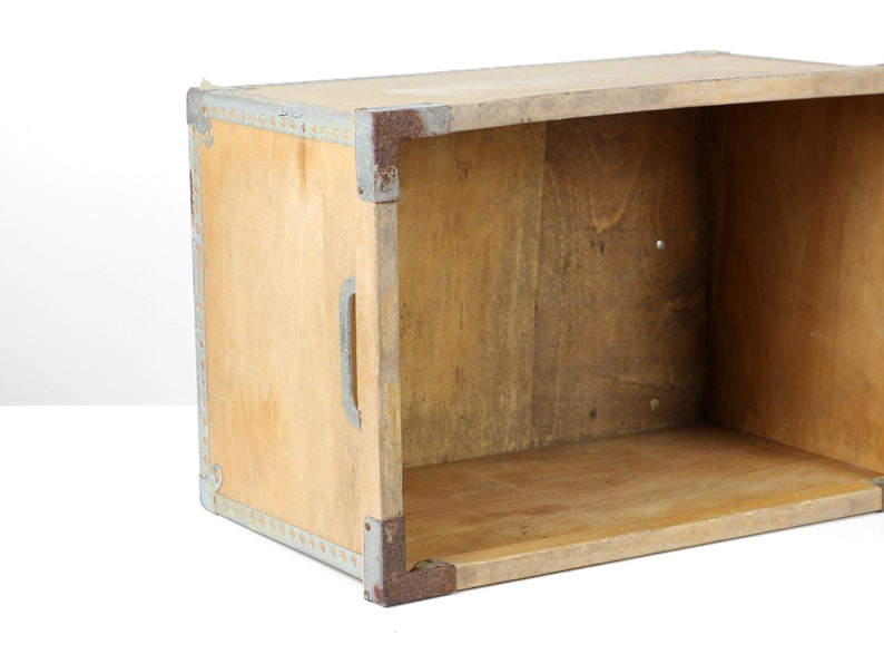 May include: A wooden box with metal trim and a handle. The box is empty and has a light brown color.
