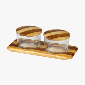 Könnte beinhalten: Zwei Glasbehälter mit Holzdeckeln und einem Holztablett. Die Behälter und das Tablett haben ein gestreiftes Muster in Brauntönen.