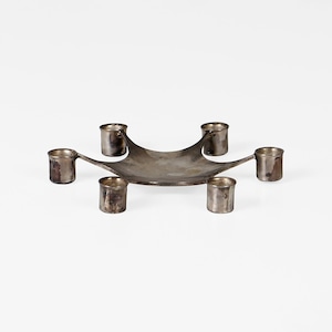 May include: A silver candelabra with six candle holders. The holders are arranged in a star shape with a central base.