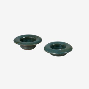 May include: Two teal blue ceramic egg cups. The cups are round and have a slight lip around the top.