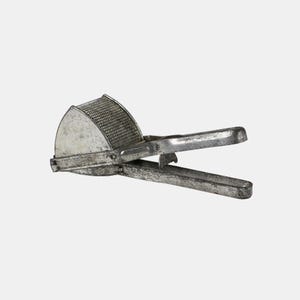 Könnte beinhalten: Ein silberfarbener Kartoffelstampfer, ein Küchenutensil zum Pressen von gekochten Kartoffeln. Er hat eine perforierte Schüssel und lange Griffe. Der Kartoffelstampfer aus Metall hat ein Vintage-Aussehen und ist gut gebraucht.