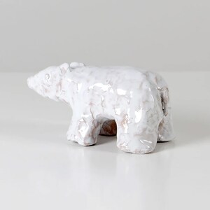 Op de afbeelding: Witte keramische ijsbeerfiguur met een getextureerd oppervlak. De beer staat op alle vier poten en heeft een licht afgerond lichaam.