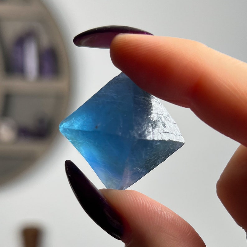 Puede incluir: Un cristal de fluorita azul en forma de pir&aacute;mide.