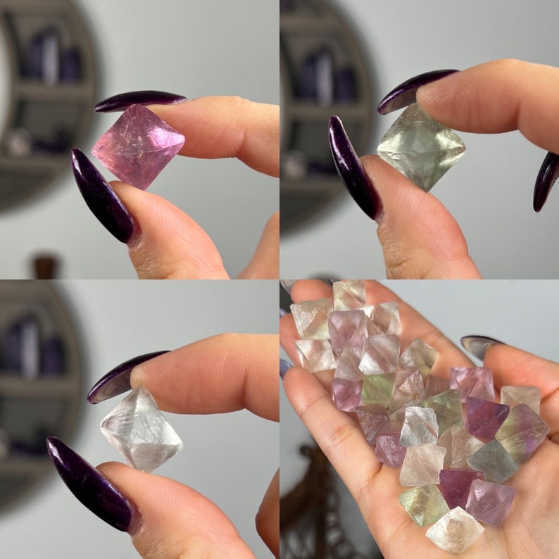 May include: A collection of fluorite crystals in various shades of pink, green, and purple. The crystals are octahedral in shape and have a glassy lustre.