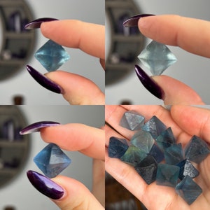 Puede incluir: Una colecci&oacute;n de octaedros de fluorita azules y verdes, algunos son pulidos y otros son en bruto, los cristales se muestran en una mano.