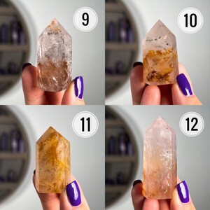 May include: Four clear quartz crystal points with inclusions of brown and orange. The crystals are displayed on a white background with numbers 9, 10, 11, and 12.