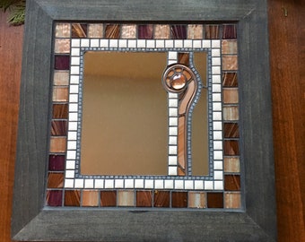 Mosaic mirror with tiles, stained glass, glass beads and copper wire in a wood frame.