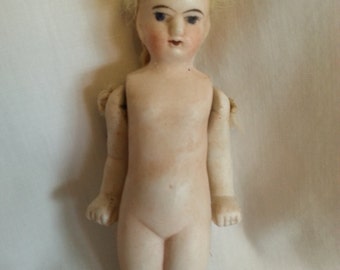 Antique Frozen Charlotte with hinged arms and hair
