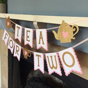 May include: A pink and gold glitter banner that reads "Tea for Two". The banner features a teapot and teacup with hearts.
